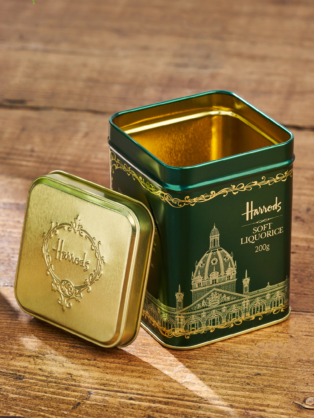 Una lata de envasado Harrods verde para dulces. El oro está grabado en el diseño verde.  