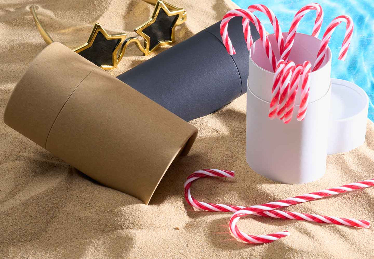 Embalaje de tubo de cartón en la playa con adornos navideños