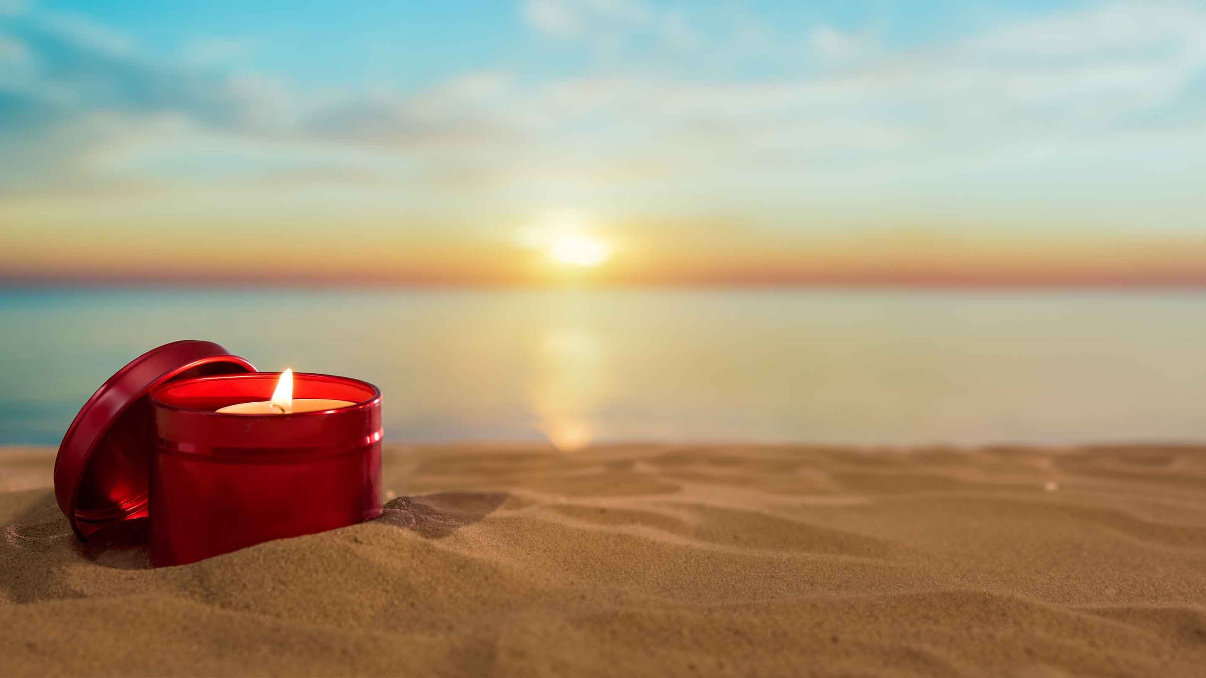 Embalaje de lata de vela roja en la playa