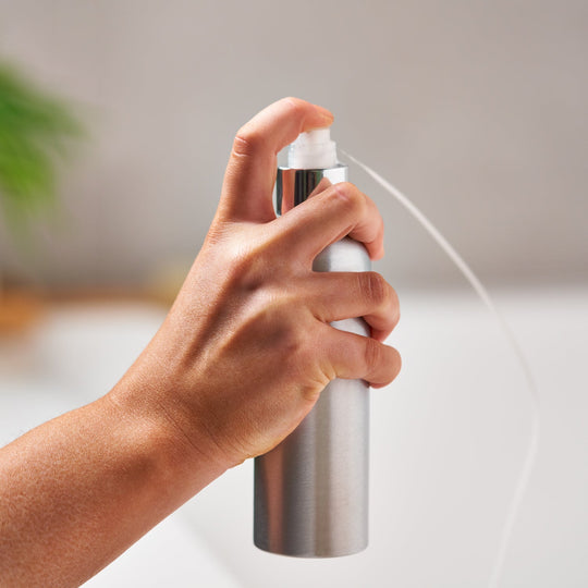 Botella de aluminio con cabezal de spray en uso