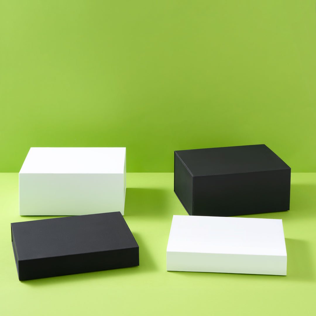 Colección de cajas de regalo en blanco y negro sobre fondo verde
