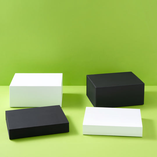 Colección de cajas de regalo en blanco y negro sobre fondo verde

