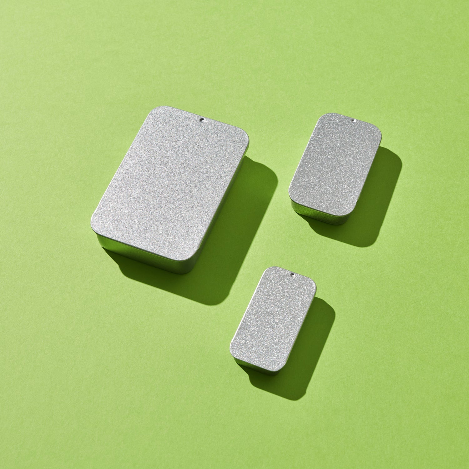 onjunto de cajas de lata rectangulares en varios tamaños sobre fondo verde